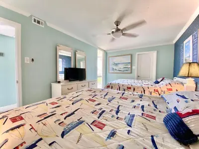 a large bedroom with two beds and a television at Pelican Walk 212 in Panama City Beach