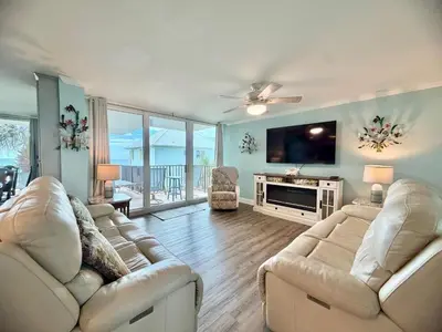 a living room with two couches and a flat screen tv at Pelican Walk 212 in Panama City Beach