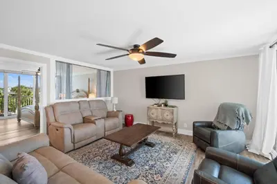 a living room with a couch and a ceiling fan at Pelican Walk 301 in Panama City Beach