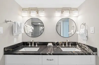 a bathroom with two sinks and two mirrors at Pelican Walk 301 in Panama City Beach