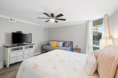 a bedroom with a bed and a flat screen tv at Pelican Walk 301 in Panama City Beach