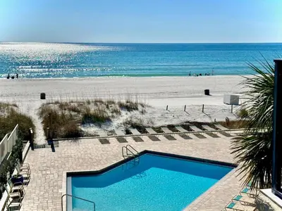 a swimming pool next to a beach with the ocean at Pelican Walk 301 in Panama City Beach