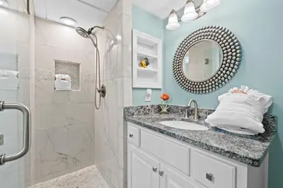 a bathroom with a sink and a shower with a mirror at Pelican Walk 810 in Panama City Beach