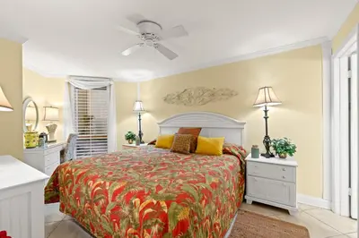 a bedroom with a bed and a ceiling fan at Pelican Walk 103 in Panama City Beach