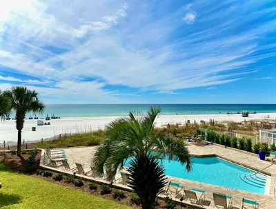 a view of a beach with a swimming pool and chairs at Pelican Walk 103 in Panama City Beach