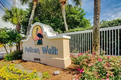 a sign for a villas walk sign with flowers at Pelican Walk 103 in Panama City Beach