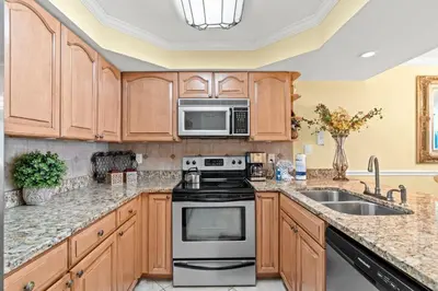 a kitchen with a stove and a microwave at Pelican Walk 103 in Panama City Beach