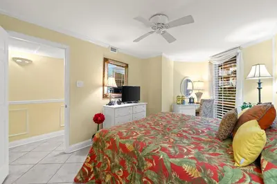a bedroom with a bed and a ceiling fan at Pelican Walk 103 in Panama City Beach