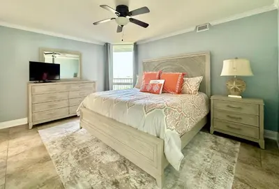 a bedroom with a bed and a ceiling fan at Pelican Walk 908 in Panama City Beach