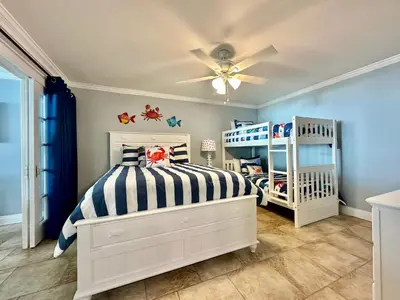 a bedroom with a bed and a ceiling fan at Pelican Walk 908 in Panama City Beach