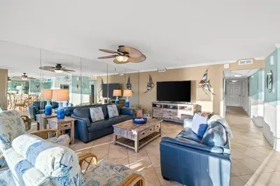 a living room with blue furniture and a flat screen tv at Pelican Walk 406 in Panama City Beach