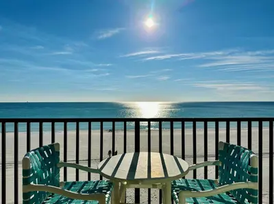 a table and chairs on a balcony with the ocean at Pelican Walk 406 in Panama City Beach