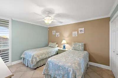 a bedroom with two beds and a ceiling fan at Pelican Walk 406 in Panama City Beach
