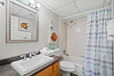 a bathroom with a sink and a toilet and a tub at Pelican Walk 911 in Panama City Beach
