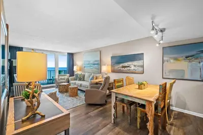 a living room with a table and a dining room at Pelican Walk 911 in Panama City Beach