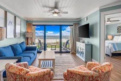 a living room with a blue couch and a tv at Gulfgate 102 in Panama City Beach