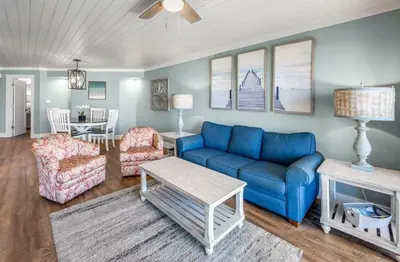 a living room with a blue couch and chairs at Gulfgate 102 in Panama City Beach