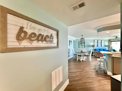 a living room with a kitchen and a dining room at Gulfgate 102 in Panama City Beach