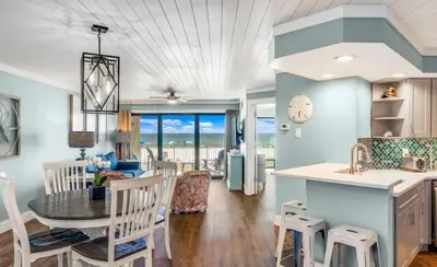 a kitchen and dining room with a table and chairs at Gulfgate 102 in Panama City Beach