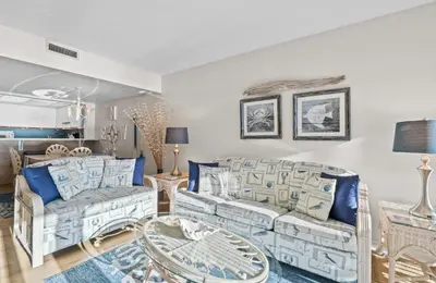 a living room with two couches and a table at Pelican Walk 704 in Panama City Beach