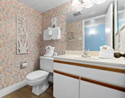 a bathroom with a toilet and a sink and a mirror at Pelican Walk 704 in Panama City Beach