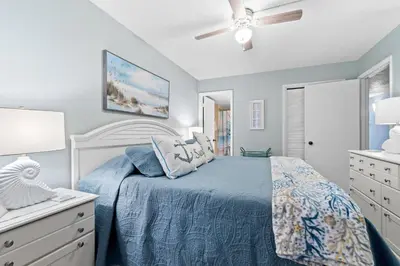 a bedroom with a bed and a ceiling fan at Pelican Walk 704 in Panama City Beach