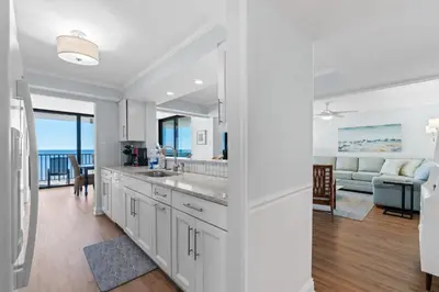a kitchen and living room with a view of the ocean at Pelican Walk 1008 in Panama City Beach