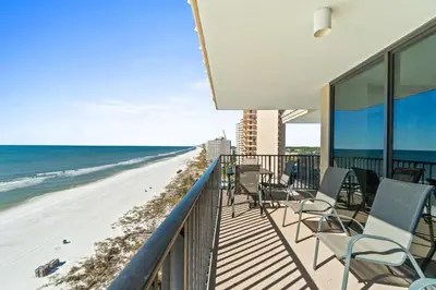 a balcony with chairs and a view of the beach at Pelican Walk 1008 in Panama City Beach
