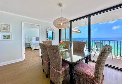 a dining room with a table and chairs with a view of the ocean at Pelican Walk 1008 in Panama City Beach