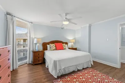 a bedroom with a bed and a ceiling fan at Pelican Walk 1008 in Panama City Beach