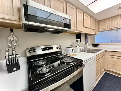 a kitchen with a black stove and a microwave at Gulfgate 103 in Panama City Beach