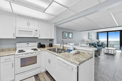 a kitchen with white appliances and a view of the ocean at Pelican Walk 804 in Panama City Beach