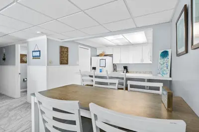 a dining room and kitchen with a table and chairs at Pelican Walk 804 in Panama City Beach