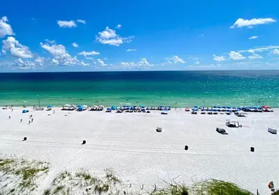 a beach with a lot of umbrellas and the ocean at Pelican Walk 804 in Panama City Beach