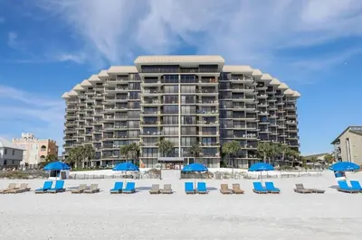 a large building on the beach with chairs and umbrellas at Pelican Walk 804 in Panama City Beach