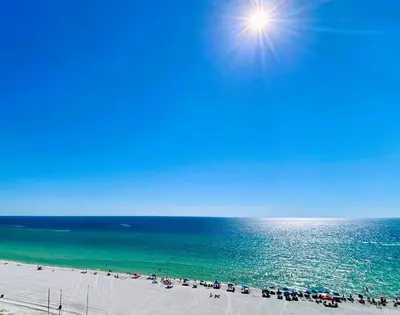 a view of a beach with the sun over the ocean at Pelican Walk 1006/1007 in Panama City Beach