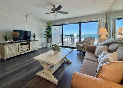 a living room with a couch and a tv and a table at Gulfgate 205 in Panama City Beach