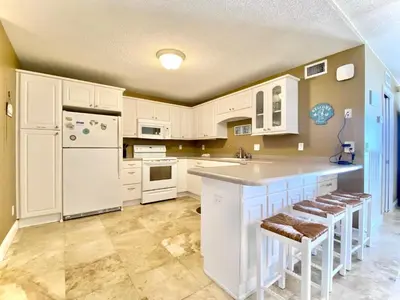 a kitchen with white cabinets and a white refrigerator at Gulfgate 201 in Panama City Beach