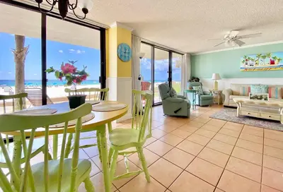a living room with a table and chairs with a view of the ocean at Pelican Walk 107 in Panama City Beach