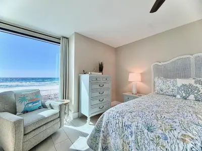a bedroom with a bed and a chair and a window at Gulfgate 204 in Panama City Beach