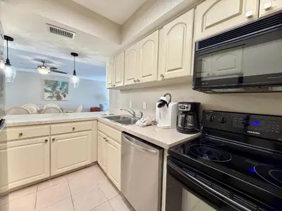 a kitchen with white cabinets and a black appliance at Gulfgate 204 in Panama City Beach