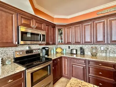 a kitchen with wooden cabinets and a stove top oven at Pelican Walk 307 in Panama City Beach