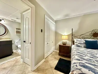 a bedroom with a bed and a bathroom at Pelican Walk 307 in Panama City Beach