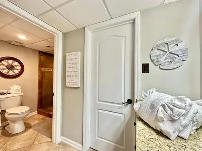 a bathroom with a toilet and a white door at Pelican Walk 307 in Panama City Beach