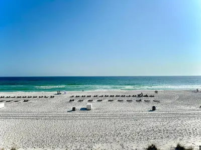 a beach with a bunch of umbrellas and the ocean at Pelican Walk 307 in Panama City Beach