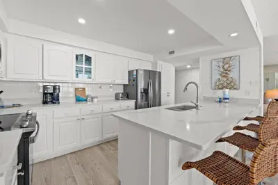 a kitchen with white cabinets and a large white counter top at Pelican Walk 207 in Panama City Beach