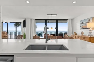 a kitchen and living room with a view of the ocean at Pelican Walk 207 in Panama City Beach