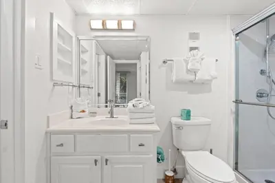 a white bathroom with a toilet and a sink at Pelican Walk 207 in Panama City Beach
