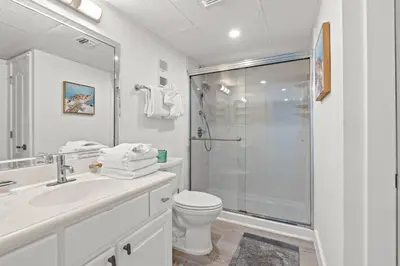 a white bathroom with a shower and a toilet at Pelican Walk 207 in Panama City Beach