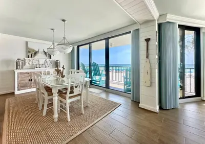 a dining room with a table and views of the ocean at Pelican Walk 206 in Panama City Beach